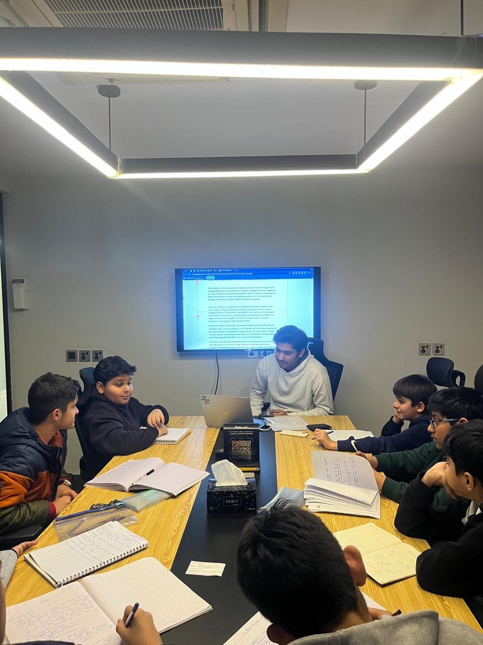 Coach Zeenur leading a WSC preparation session around the table